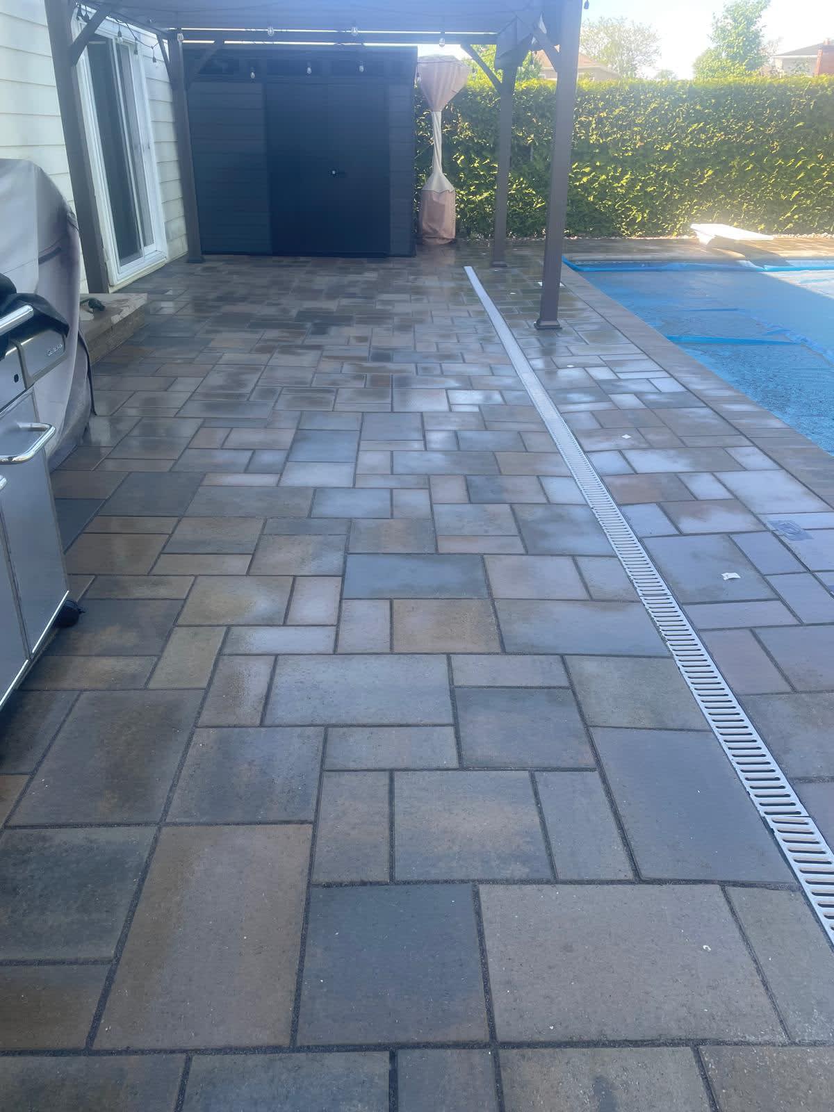 Pool deck with interlock surround, pergola and drainage channel
