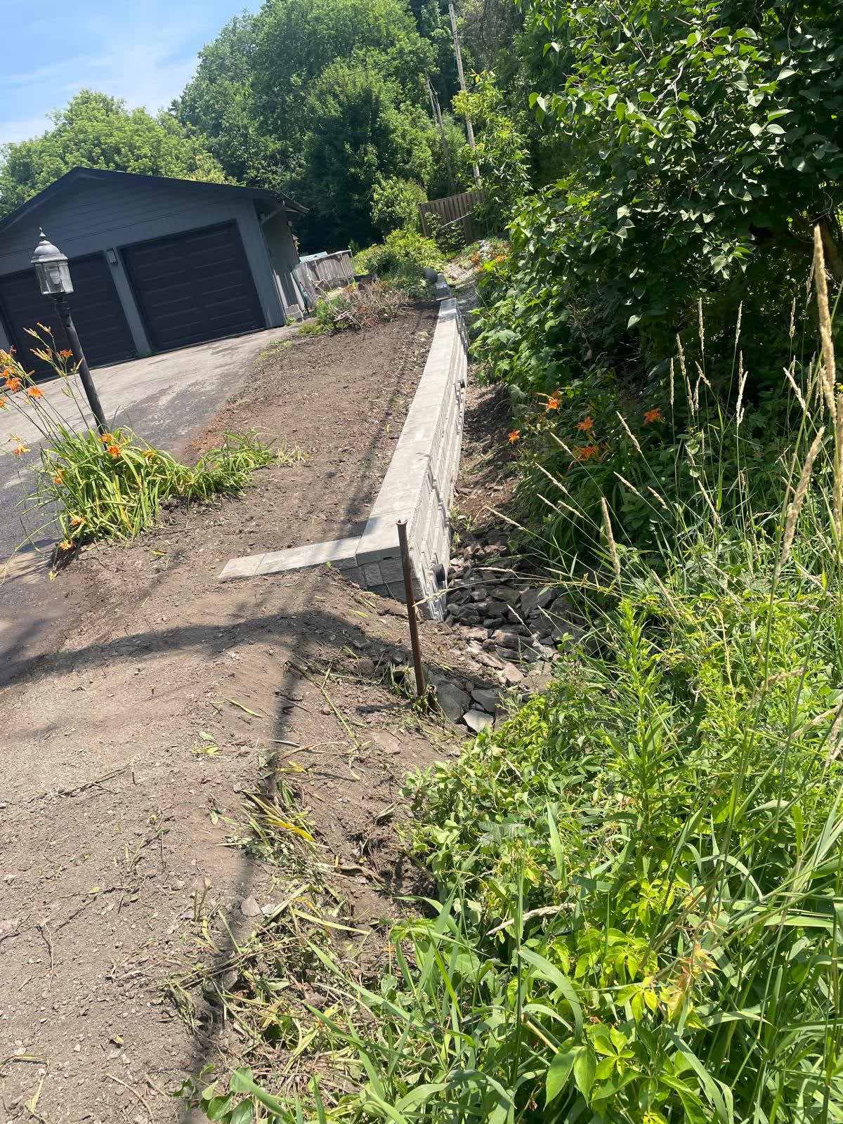 Retaining wall installation beside driveway
